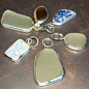 sea-glass mounted in silver bezels, six in number of assorted shapes and sizes, as pendants to go onto chains which are not pictured.